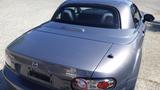 A 2007 Mazda Miata with a sleek gray exterior featuring rounded taillights a compact rear design and a smooth roofline