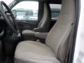 Interior view of a 2011 Chevrolet Express with two front seats in light gray fabric and a steering wheel visible in the foreground