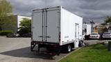 A white 2016 Hino 195 box truck parked on a street with a closed rear door and a black bumper