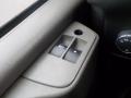Interior panel of a 2011 Chevrolet Express featuring window control switches and a knob for adjusting settings