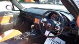A 2007 Mazda Miata interior featuring black and orange leather seats a modern dashboard with circular gauges and a central display console