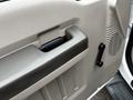 Interior door handle of a 2009 Ford F-550 with textured panel and speaker grille visible