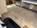 Interior view of a 2008 Ford Econoline van showing a wooden floor and empty cargo space with shelves along the sides