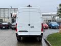 A 2023 Mercedes-Benz Sprinter van viewed from the rear with a white exterior and distinctive logos on the back door