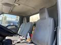 Interior of a 2014 Hino 195 showing two gray fabric seats and a steering wheel with a bottle and cup in the cup holder