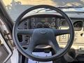 The interior view of a 2005 Freightliner M2 106 featuring a black steering wheel with various controls and gauges on the dashboard
