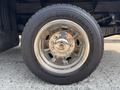 A chrome wheel with a polished rim and a Continental tire mounted on a 2009 Ford F-450 Super Duty