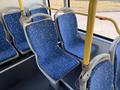 Interior seating of a 2016 Grande West Vicinity bus featuring blue patterned fabric and gray plastic frames with a view of the bus's interior layout