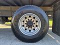 A large Goodyear truck tire mounted on a metal rim with multiple bolt holes visible in the center