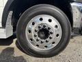 Close-up of a shiny chrome wheel on a 2013 RAM 5500 featuring a black tire with visible tread and multiple lug nuts securing it to the rim