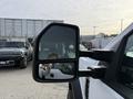 A side mirror of a 2020 Ford F-550 reflecting part of the truck and a person in the foreground