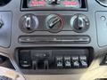 Dashboard controls of a 2008 Ford F-550 featuring temperature dials air conditioning buttons and multiple auxiliary switches