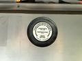 A circular label attached to a surface indicating specifications for camber and caster angles for a vehicle alignment system