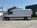 A 2019 Mercedes-Benz Sprinter van in white with a sleek design and distinct wheels parked in profile view