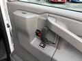 Interior door handle of a 2023 GMC Savana with a gray panel and control buttons