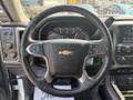 A 2017 Chevrolet Silverado 1500 steering wheel featuring a Chevrolet logo and various controls for media and cruise settings