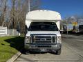 A white 2014 Ford Econoline with a large van body and front grille facing the viewer