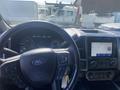 The dashboard of a 2019 Ford F-150 with a steering wheel digital speedometer and a touch screen interface displaying radio options
