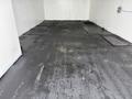 A 2012 Ford F-550 parked inside a clean empty space with a dark floor and no visible items around it