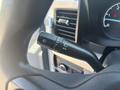 A black control lever featuring icons for windshield wipers and headlights in a vehicle interior