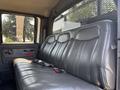 Interior view of the backseat of a 2005 GMC C7500 Topkick featuring black leather upholstery and seatbelt attachments
