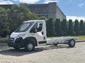 A 2023 RAM Promaster 3500 van in white with a flat chassis and no cargo box is positioned in the foreground