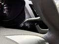 A close-up of the steering wheel controls in a 2017 Ford Transit Connect featuring levers for windshield wipers and lights
