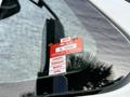 A red and white certificate of approval sticker affixed to the windshield of a 2011 International WorkStar vehicle displaying the months January to April