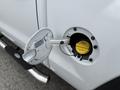 Close-up of the fuel filler cap of a 2016 GMC Sierra 1500 with the cap opened and a yellow fuel label visible