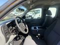 Interior view of a 2013 Chevrolet Silverado 1500 featuring a driver's seat, steering wheel, and center console with cup holders