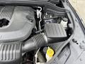 An overhead view of the engine compartment of a 2015 Dodge Durango showing the air intake hose battery and other engine components