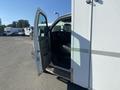 A 2011 Chevrolet Express van with its driver side door open showcasing the interior and dashboard