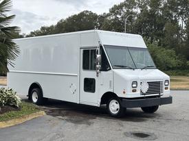 A white 2018 Ford Econoline cargo van with a rectangular body and large front windshield parked on a lot