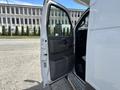 A 2020 Chevrolet Express van with an open driver's side door revealing the interior and control panel