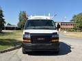 Front view of a 2019 GMC Savana van with a white roof rack and a black bumper