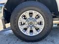 Close-up of a 2020 Ford F-350 SD wheel showcasing a large, shiny chrome rim and a rugged all-terrain tire with prominent tread design