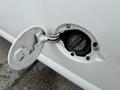 Close-up of the fuel cap door of a 2004 Chevrolet Express revealing the fuel filler neck and cap