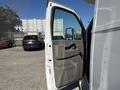 A 2020 Chevrolet Express van with the driver's side door open showcasing the interior panel and mirror