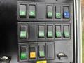 Control panel of a 2004 Bombardier SW48 featuring various switches with green and black buttons for operating different functions