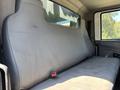 A gray bench seat inside a 2011 International 4300 truck with a seatbelt and no visible occupants