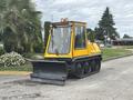 A yellow 2004 Bombardier SW48 tracked vehicle with a snowplow attachment positioned in front ready for use