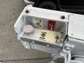 Control panel for a 2001 Ford F-350 featuring buttons for outer boom and rotation along with an emergency power switch and a pink cap