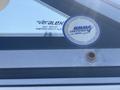 A close-up of a sticker on a boat's windshield displaying certification details and safety information