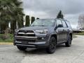A 2021 Toyota 4Runner in gray with black accents parked on a driveway, featuring a distinctive front grille and rugged design