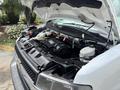 A 2020 Chevrolet Express van with its hood open displaying the engine compartment and various mechanical components