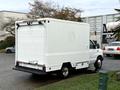 A white 2007 Ford E-350 cargo van is parked with the rear doors closed and a step bumper visible at the back