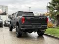 A 2022 GMC Sierra 3500HD pickup truck in black with visible design features like a large tailgate and prominent rear lights