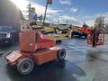 A 2012 JLG E400AJFN articulated boom lift with an orange and beige color scheme, featuring a platform at the end of its extendable arm