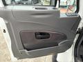 The interior door panel of a 2012 International 7400 featuring a handle a speaker area and controls for windows and locks