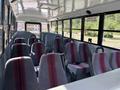 Interior of a 2011 Freightliner B2 school bus featuring multiple rows of gray seats with red stripes and grab handles